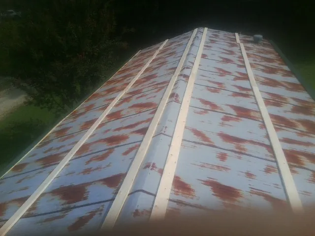 Rusted metal roof panels with new wood purlins before replacement — Storm Damage Roof Repair in Napoleon by Roofing Brothers